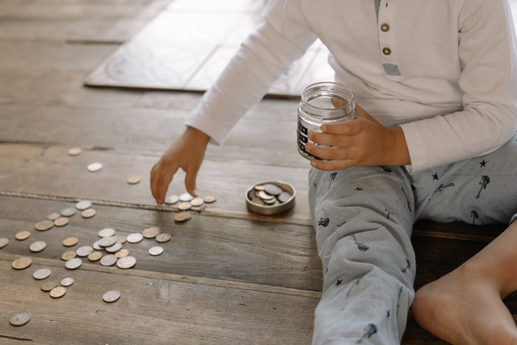 child sitting on the ground collecting coins