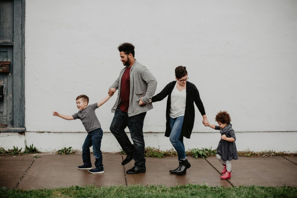 parents holding two kids hands