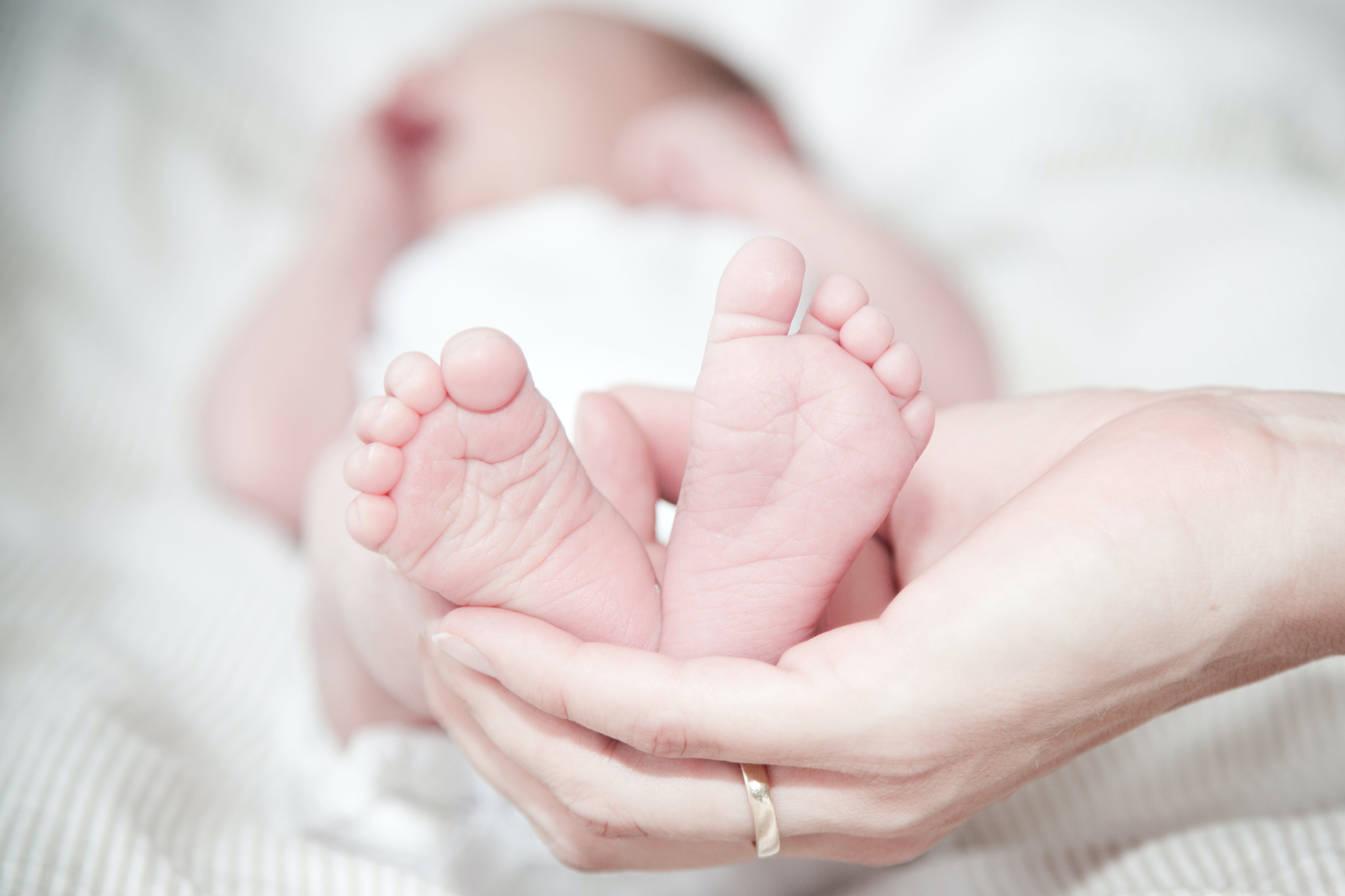 Hand around a new born baby's feet