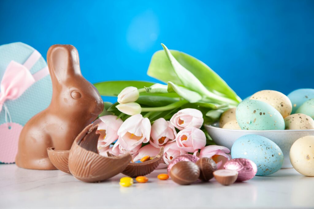 Photo of a chocolate bunny and some chocolate eggs and flowers